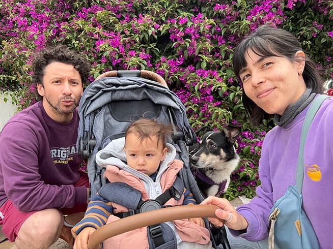 Rober con gorro de lana y Andre con Dante en el cochecito, Zama al lado, en la vereda de su barrio